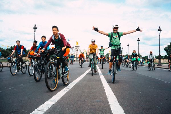 A group of cyclists ride down a street