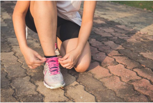 Runner kneels to ties up her laces