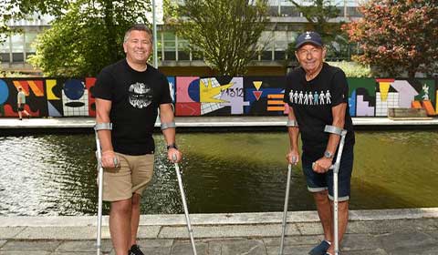 Spencer and his father Dave stand on crutches