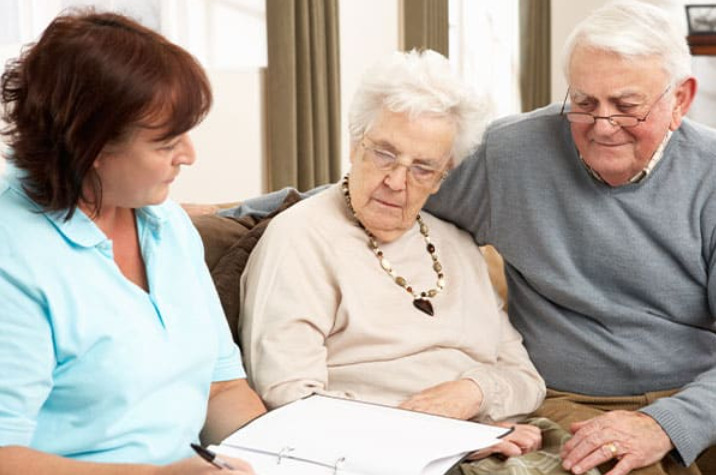 Elderly couple talk to a woman about their NHS surgery